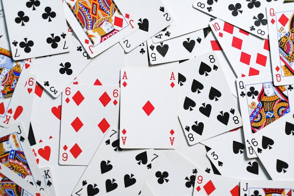 A collection of scattered playing cards showcasing various suits and numbers for casino themes.
